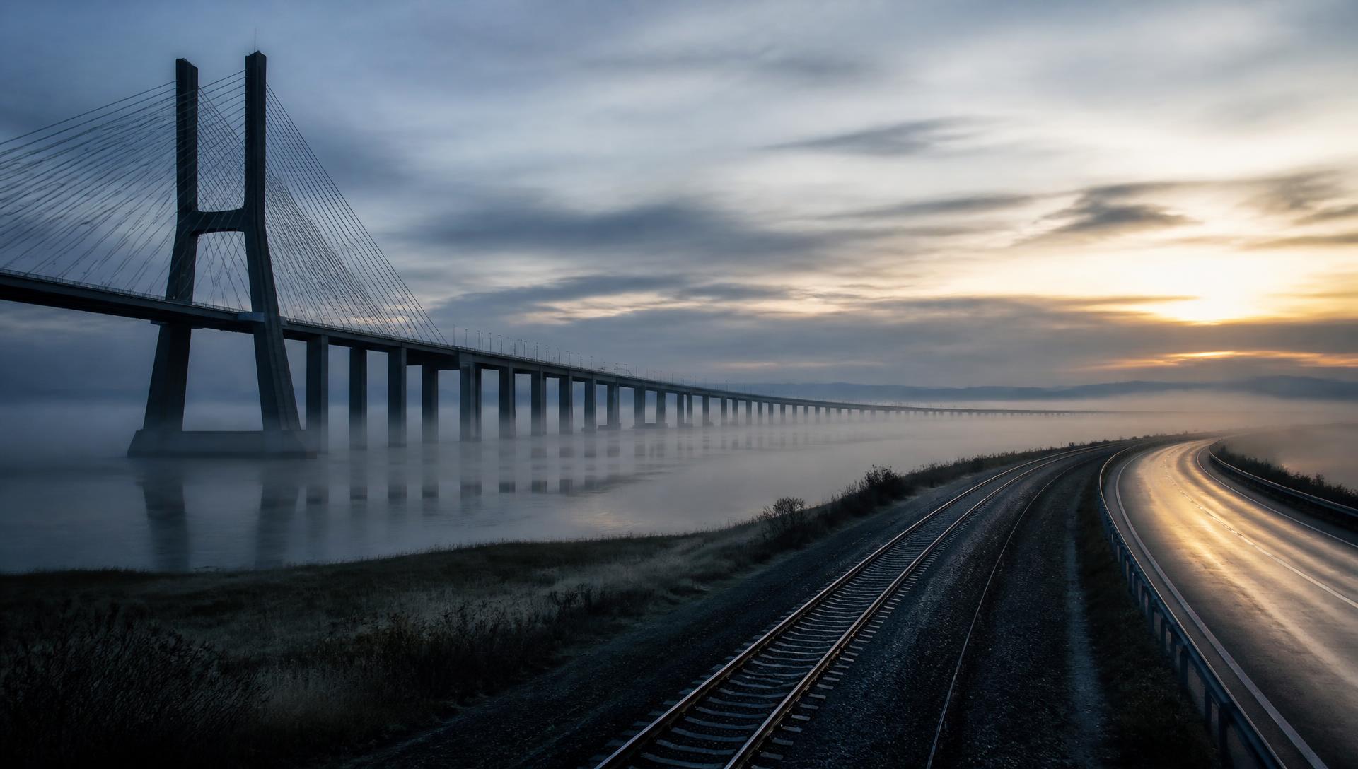 Long modern bridge and rail corridor at dawn