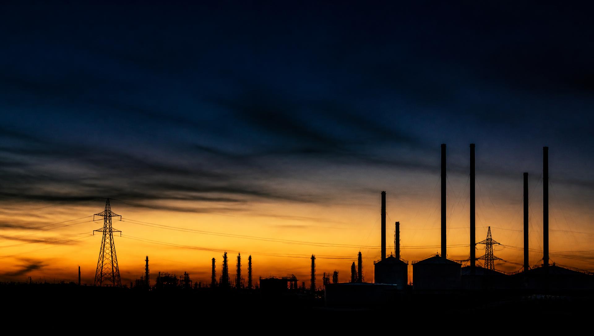 Abstract silhouette of energy infrastructure against a dusk sky